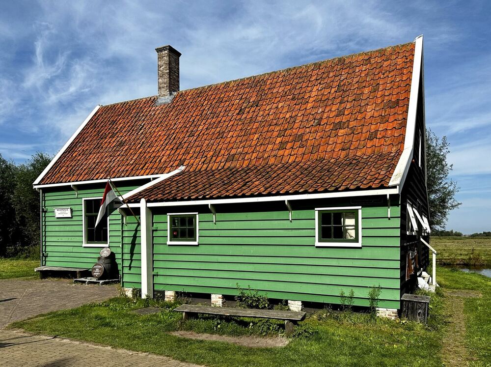 Het Zaansgroene Wevershuis op de Zaanse Schans onder een blauwe lucht